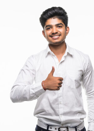 Portrait of excited man in formal wear giving thumbs-up against gray background