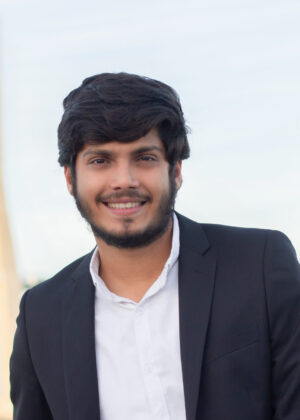 Portrait of good-looking smiling Arabic man in suit. Attractive young businessman with beard and moustache looking at camera. Portrait, international, beauty concept